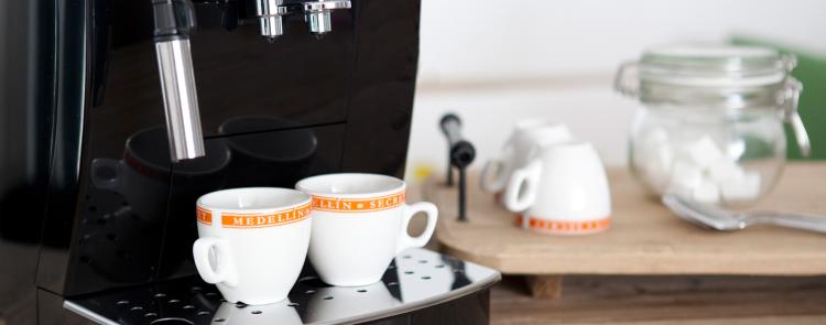 Schwarzer Kaffeevollautomat mit Tassen