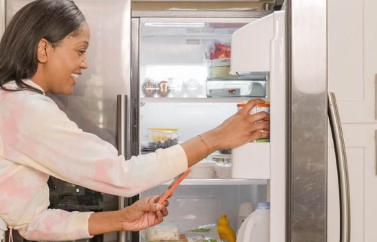 frau am kuehlschrank
