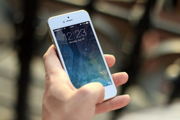 Weißes iPhone wird in Hand gehalten